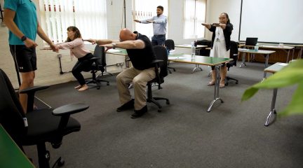 Group of coworkers taking part in Chairobics