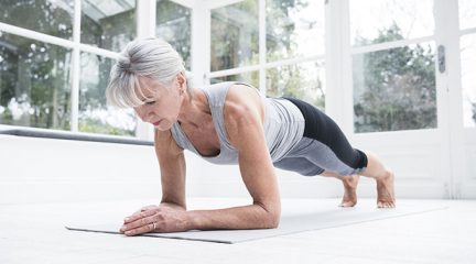 An older woman doing a plank exercise at home